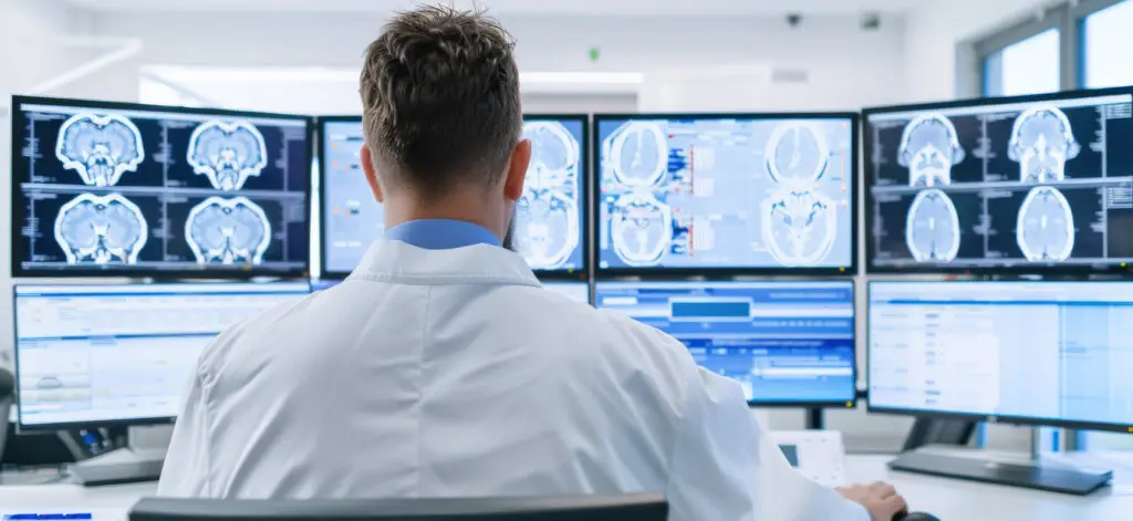 Medical professional analyzing brain scans on multiple monitors, demonstrating the power of e-consults, and consulting specialists in modern healthcare.